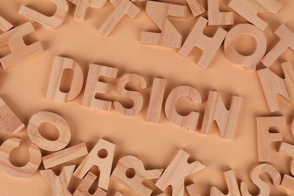 Wooden letters arranged to form the word 'design' on a brown background, top view.